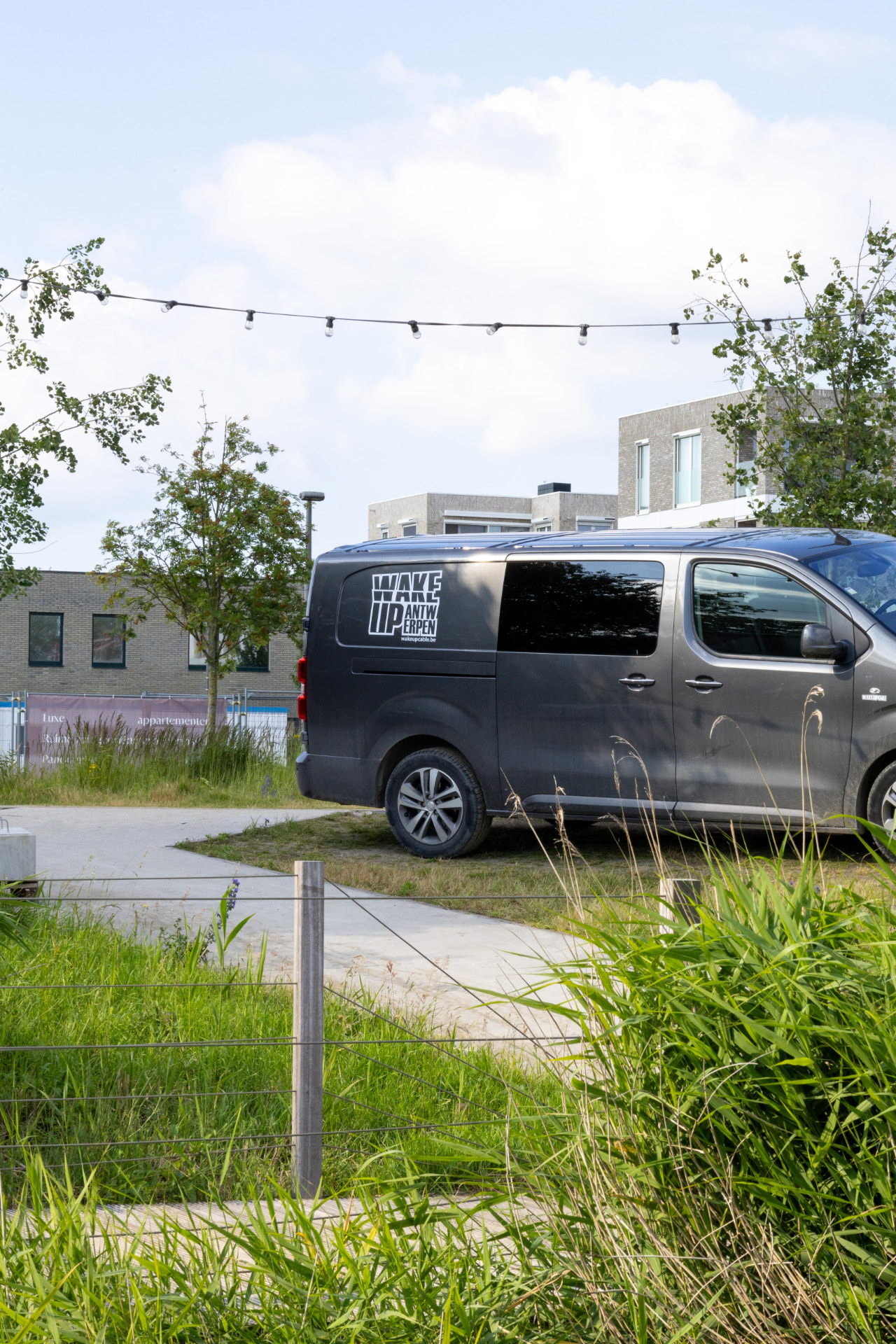 Branded Wake Up Antwerpen van parked near the water
